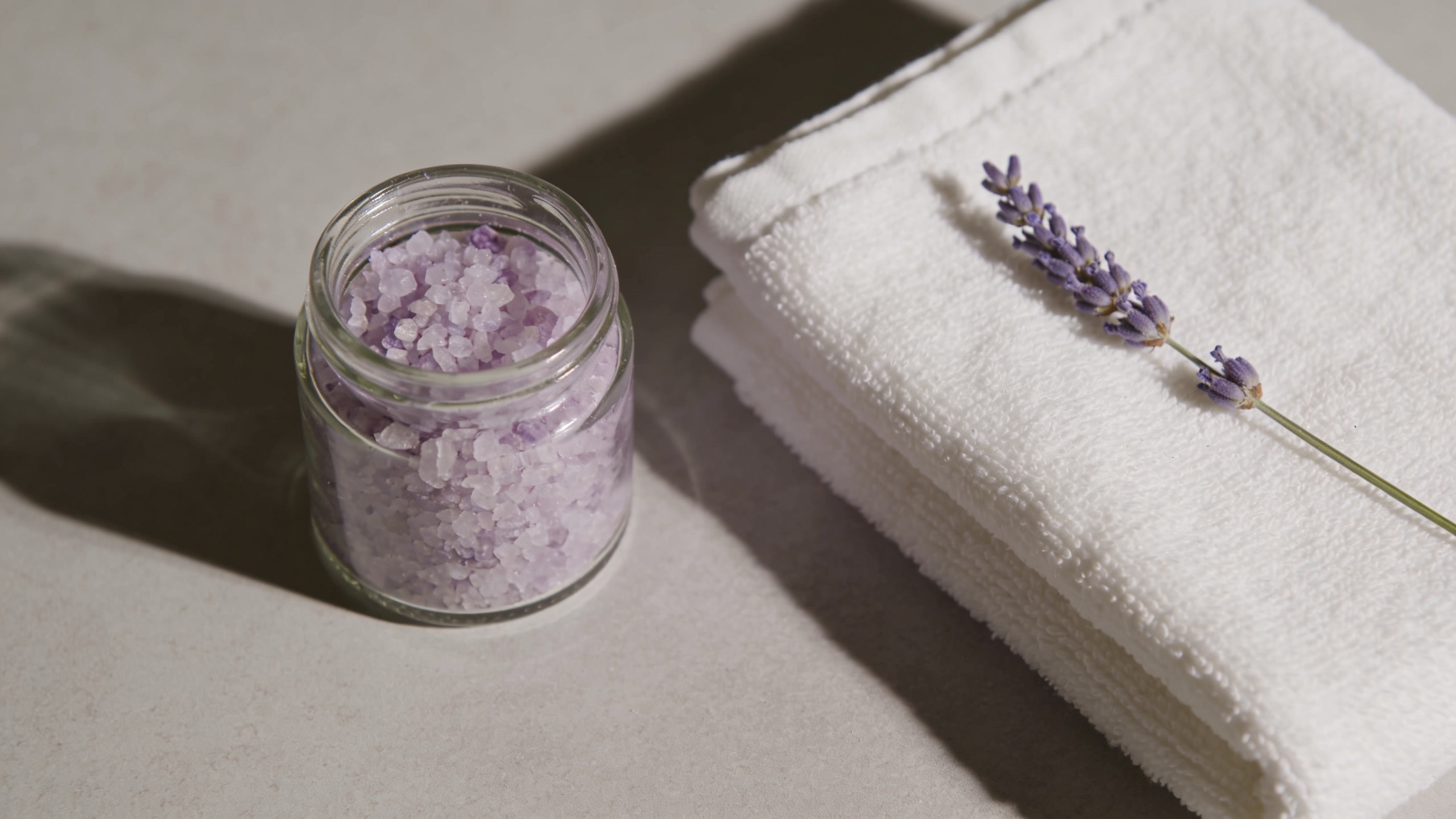 Photo of a bottle of bath oil next to a filled bathtub